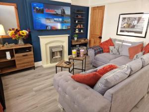 a living room with a couch and a fireplace at The Nook Cosby Village 