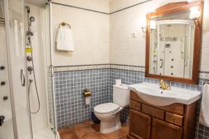 a bathroom with a toilet and a sink and a shower at Apartamentos Cruz Mar in Poveda de la Sierra +60 photos