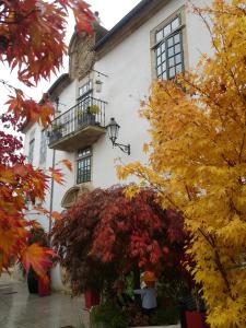 un edificio blanco con balcón y hojas de otoño en Hotel Monumento Pazo de Orbán en Lugo