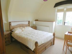 Un dormitorio con una cama grande y una ventana en Cotswold Charm George Barn en Chipping Campden