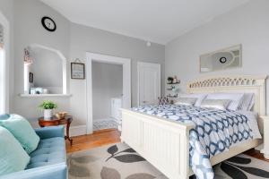 a white bedroom with a bed and a blue couch at G7 central location museums free parking in Richmond