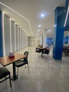 a hallway with tables and chairs in a building at Rota 232 Hotel Caruaru in Caruaru