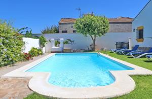 een zwembad in de tuin van een huis bij Chalet la Dehesa in Conil de la Frontera