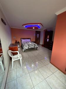 基多的住宿－Gran Magnate，一间卧室配有一张床、一把椅子和蓝色的灯光