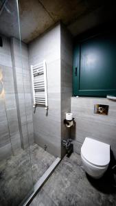 a bathroom with a toilet and a glass shower at Anbani Apartments - City Center in Tbilisi City
