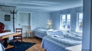1 dormitorio con 2 camas, mesa y sillas en Apelviksgården B&B en Varberg
