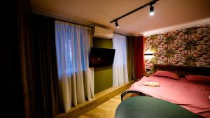 1 dormitorio con 1 cama, TV y ventana en Anbani Apartments - City Center en Tiflis