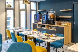 a restaurant with tables and chairs and a coffee maker at Nemea Appart Hotel Riviera Nice Aéroport in Nice