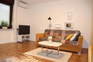 uma sala de estar com um sofá e uma mesa em Apartments ZVEZDICA*** with garden em Zambratija