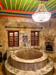 a bathroom with a large tub in a room with a chandelier at Zeydem Suites in Urgup