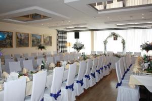 un salón de banquetes con mesas blancas y sillas blancas en Hotel Magnet, en Stryi