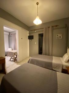 a hotel room with two beds and a television at Pansion Vasiliki in Ouranoupoli