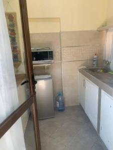 蒙巴薩的住宿－Imani’s home，小厨房配有小冰箱和微波炉