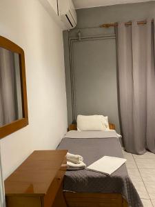 a room with a bed and a desk and a mirror at Pansion Vasiliki in Ouranoupoli