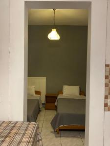 オウランオウポリにあるPansion Vasilikiのベッドルーム(ベッド2台、照明付)