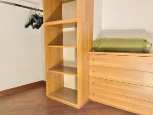 una estantería de madera con una almohada verde en una habitación en Bilocale in Piazza Duomo 4Pax, en Milán