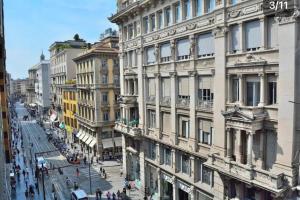 een straat met gebouwen en mensen die op straat lopen bij Bilocale in Piazza Duomo 4Pax in Milaan