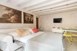 - un salon avec un canapé blanc et une table dans l'établissement MMeSuite Arena di Verona by Maisonme Collection, à Vérone