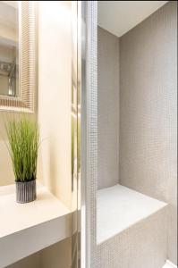 une salle de bains avec une plante assise sur une étagère dans l'établissement MMeSuite Arena di Verona by Maisonme Collection, à Vérone