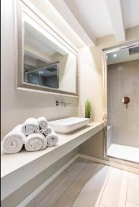 La salle de bains est pourvue d'un lavabo, d'un miroir et de serviettes. dans l'établissement MMeSuite Arena di Verona by Maisonme Collection, à Vérone