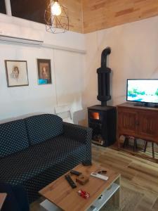 a living room with a couch and a wood stove at Rudnička čarolija in Rudnik Kačerski