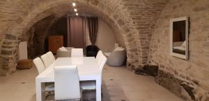 une salle à manger avec une table blanche et des chaises blanches dans l'établissement Maison d'Eusébia, à Château-Chalon