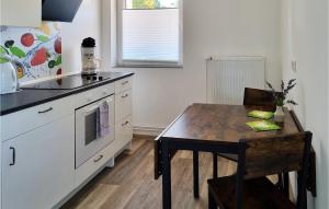 a kitchen with a wooden table and a table and a dining table and a counter at Amazing Apartment In Passow Ot Charlottenho With Lake View in Zahren