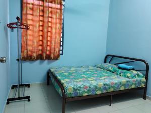 Cama en habitación con pared azul en Homestay Pekan Pahang, en Pekan