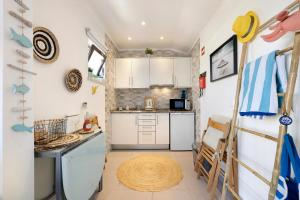 a small kitchen with white cabinets and a table at The Studio - Pet friendly in Alvor