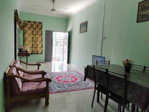 a living room with a dining room table and chairs at Homestay Pekan Pahang Semi D in Pekan