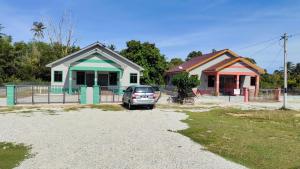 a car parked in front of two houses at Homestay Pekan Pahang Semi D in Pekan
