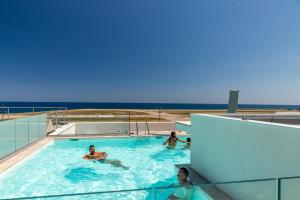 a group of people swimming in a swimming pool at Nemea Appart Hotel Riviera Nice Aéroport in Nice