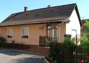 uma casa com um telhado preto e uma cerca em Kovács Vendégház em Zalaegerszeg