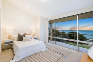 a bedroom with a bed and a large window at Swainson on Paruna in Port Adelaide