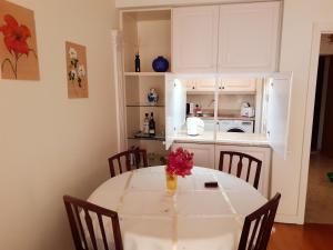 a kitchen with a table with a vase of flowers on it at One bedroom apartement with sea view shared pool and enclosed garden at Sao Martinho Funchal in Funchal