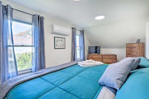 Un dormitorio con una gran cama azul y una ventana en Cozy Historic Wakefield Home Close to Beaches en South Kingstown