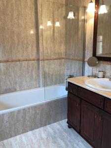 a bathroom with a tub and a sink and a mirror at Las Raucas in Colombres +19 photos