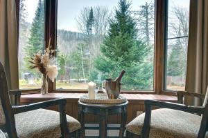a room with a table and two chairs and a window at Hôtel du Lac Lenore in Sainte-Adèle