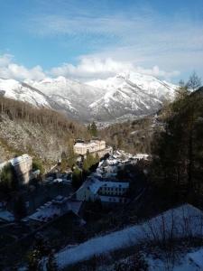 Blick auf eine Stadt mit schneebedeckten Bergen in der Unterkunft Appartement Lumineux et Rénové dans les Pyrénées in Eaux-Bonnes