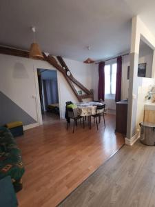 ein Wohnzimmer mit einem Tisch auf einem Holzboden in der Unterkunft Appartement Lumineux et Rénové dans les Pyrénées in Eaux-Bonnes