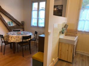 eine Küche und ein Esszimmer mit einem Tisch und einem Waschbecken in der Unterkunft Appartement Lumineux et Rénové dans les Pyrénées in Eaux-Bonnes
