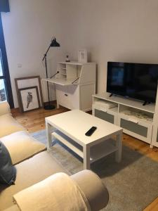 a living room with two couches and a tv at Las Raucas in Colombres