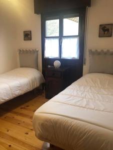 a room with two beds and a window in it at Las Raucas in Colombres