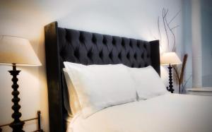 a bedroom with a bed with a black headboard and two lamps at Charming Country Retreat -Lake View Cottage with Hot tub in Wisbech Saint Mary +49 photos