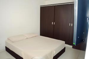 um quarto com uma cama e um armário castanho em Hotel Santo llanero em Palmira