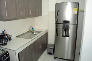uma cozinha com um frigorífico de aço inoxidável e um lavatório em Hotel Santo llanero em Palmira