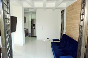 uma sala de estar com um sofá azul e uma parede de tijolos em Hotel Santo llanero em Palmira
