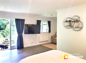 a living room with a tv and a couch at Charming Country Retreat -Lake View Cottage with Hot tub in Wisbech Saint Mary
