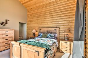 a bedroom with a bed and a wooden wall at Spacious Fairplay Cabin with Mountain Views! in Fairplay