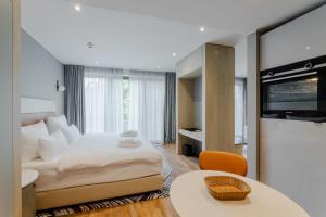 デュッセルドルフにあるFourty Three Luxury Serviced Apartmentsの大きなベッドとテーブルが備わるホテルルームです。